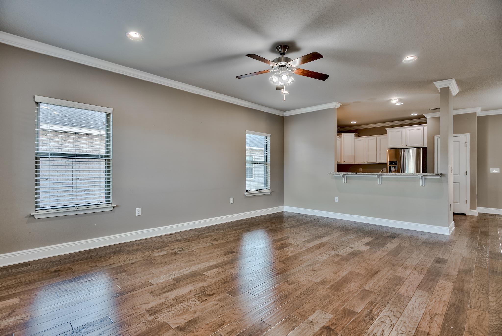242 Pin Oak Loop Santa Rosa Beach, FL 32459 - Photo 4 of 43 a view of an empty room with wooden floor and a kitchen
