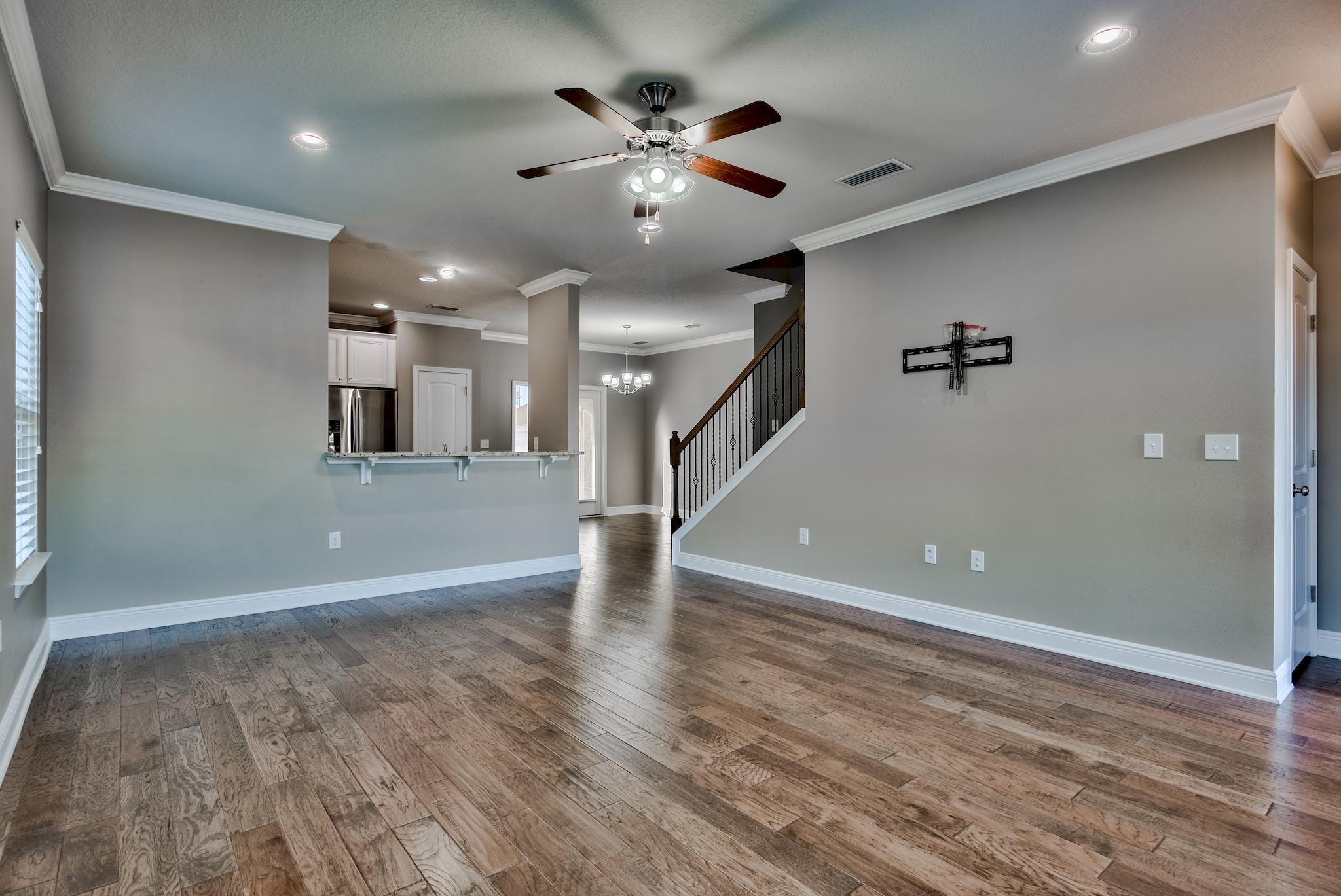242 Pin Oak Loop Santa Rosa Beach, FL 32459 - Photo 5 of 43 wooden floor in an empty room with a ceiling fan