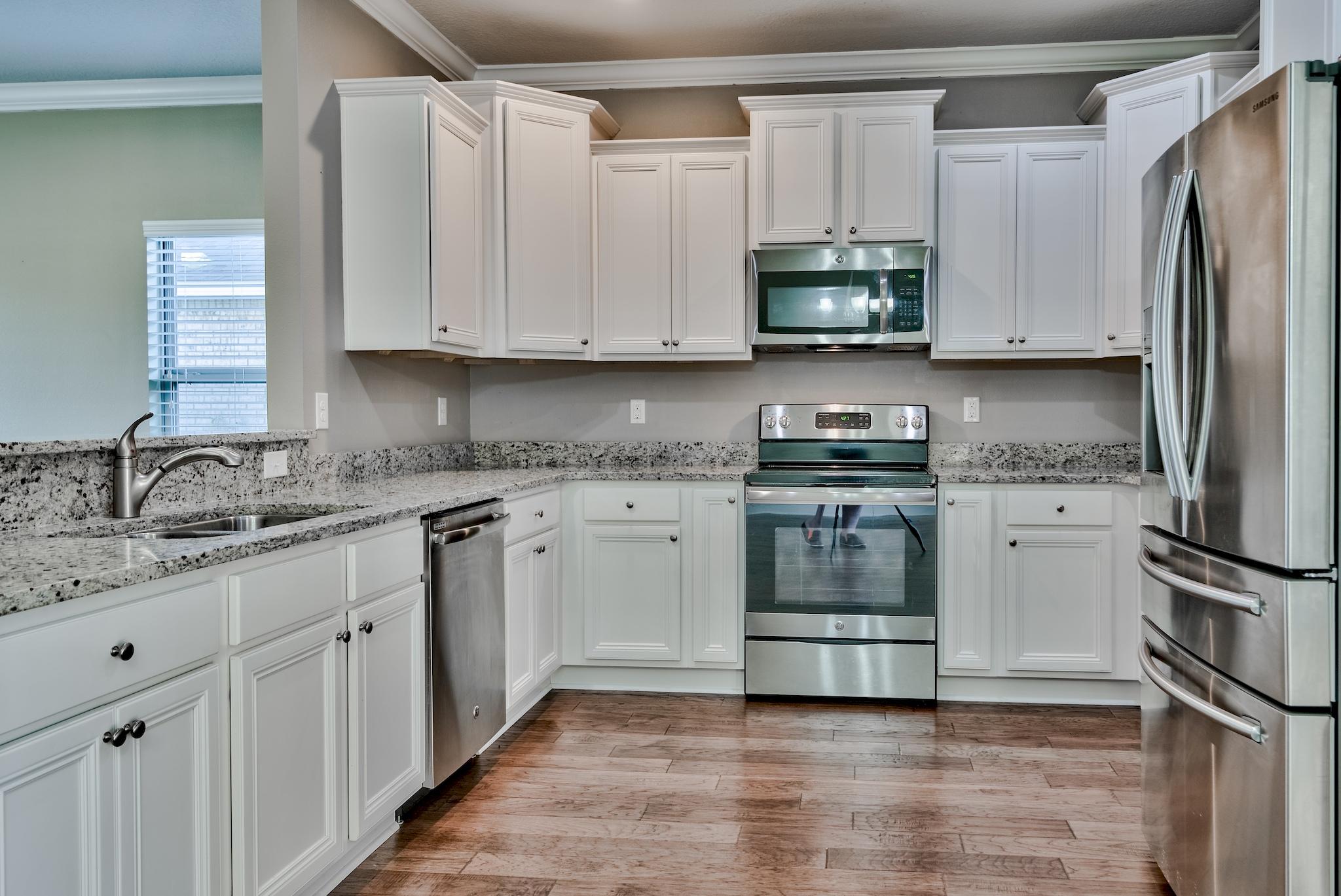 242 Pin Oak Loop Santa Rosa Beach, FL 32459 - Photo 8 of 43 a kitchen with granite countertop a refrigerator stove and sink