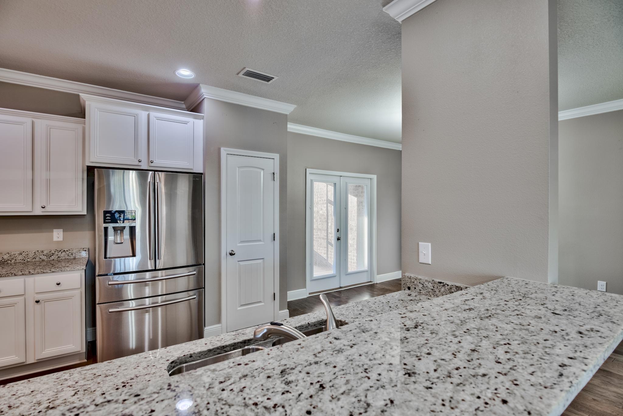 242 Pin Oak Loop Santa Rosa Beach, FL 32459 - Photo 10 of 43 a kitchen with stainless steel appliances granite countertop a refrigerator oven and a stove top oven