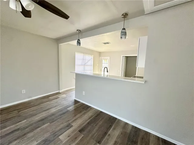 a view of a hallway with wooden floor and a cabinet