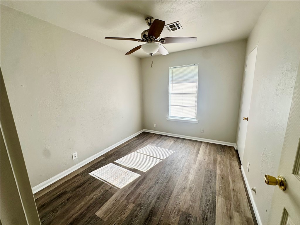 2552 Ave B Ingleside, TX 78362 - Photo 7 of 10 wooden floor in an empty room with a window