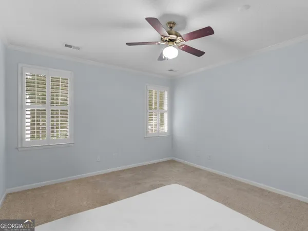 a view of a big room with wooden floor and windows