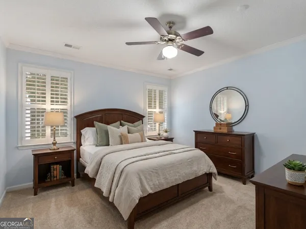 a bedroom with a bed a window and a chandelier