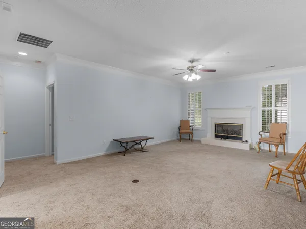 a view of a livingroom with a fireplace and a chandelier fan
