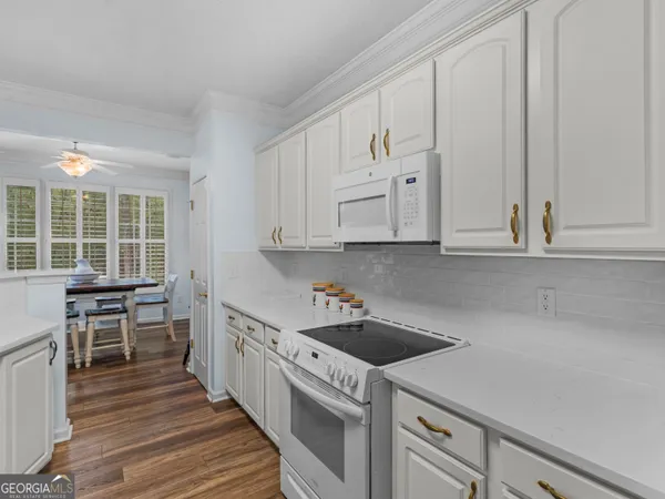 a kitchen that has a lot of cabinets in it and wooden floors