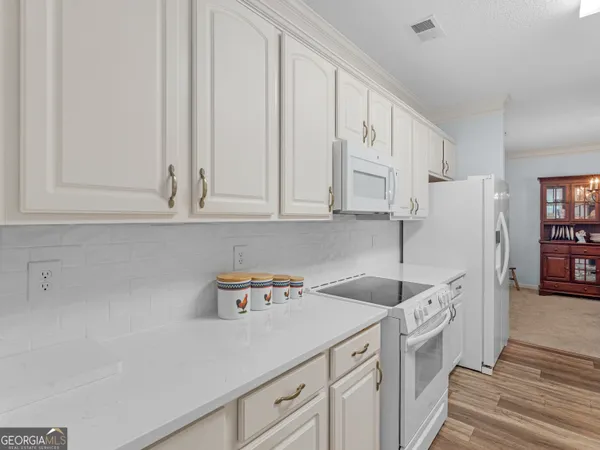a kitchen with stainless steel appliances granite countertop white cabinets and sink