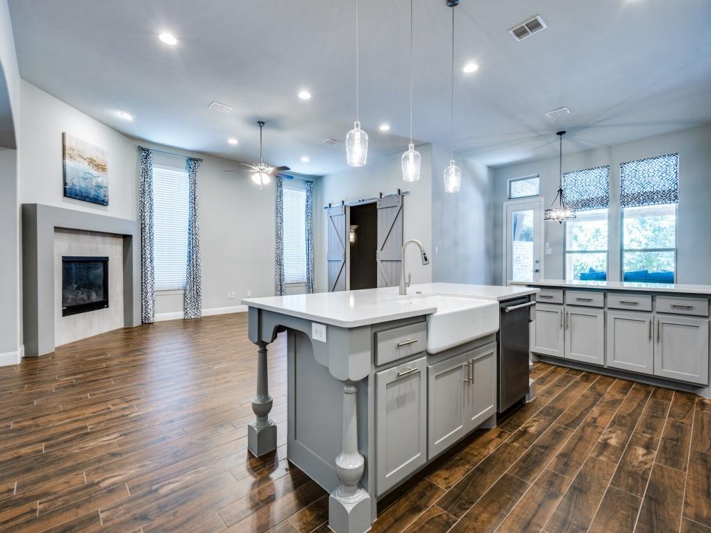 3422 Secretariat Place Celina, TX 75009 - Photo 11 of 28 a large kitchen with kitchen island a sink dishwasher a stove and a wooden floors