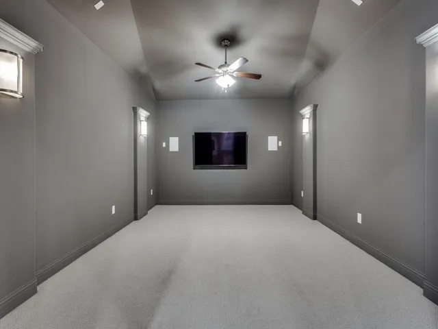 en empty room with windows and ceiling fan