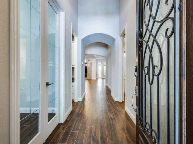 a view of a hallway with wooden floor and stairs