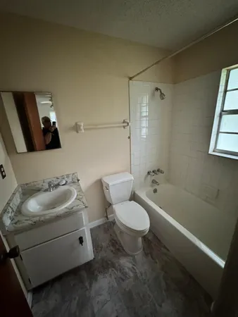 an empty room with windows and ceiling fan