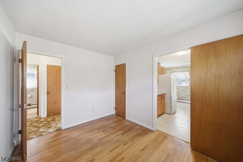 49 Heather Hills Drive Oak Ridge, NJ 07438 - Photo 16 of 34 a view of an empty room with wooden floor and a bathroom