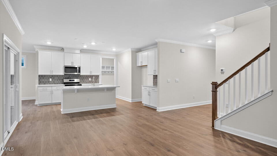 2204 Warbler Drive Apex, NC 27539 - Photo 9 of 32 a kitchen with white cabinets and stainless steel appliances