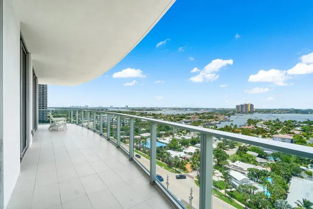 a view of a swimming pool with lawn chairs and plants