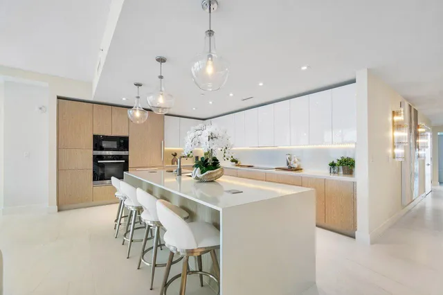 a kitchen with stainless steel appliances granite countertop a table and chairs in it