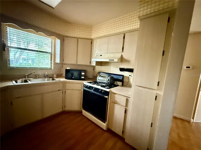a kitchen with a sink cabinets and a window