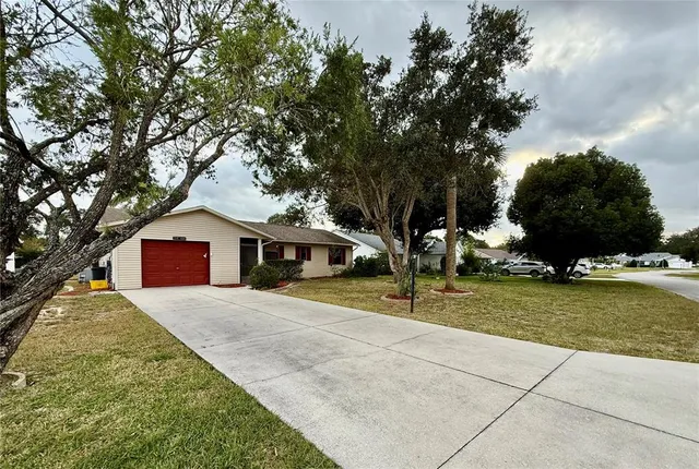 a front view of house with yard and trees around