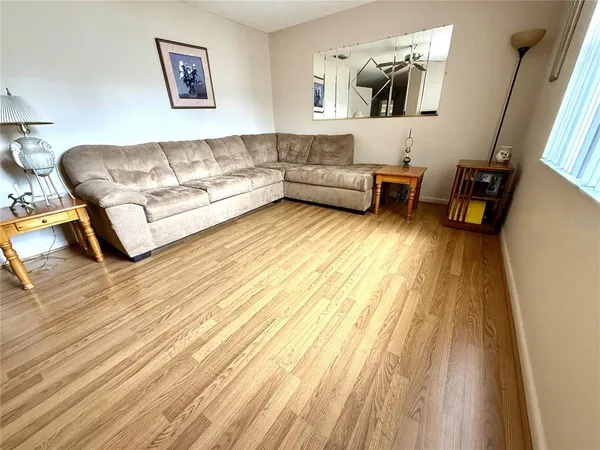 a living room with furniture and a large window with wooden floor