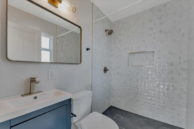 a bathroom with a toilet a sink and mirror