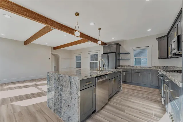 a kitchen with stainless steel appliances granite countertop a stove and cabinets