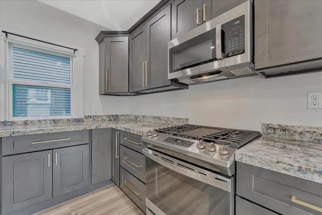 a kitchen with stainless steel appliances granite countertop a stove and a microwave