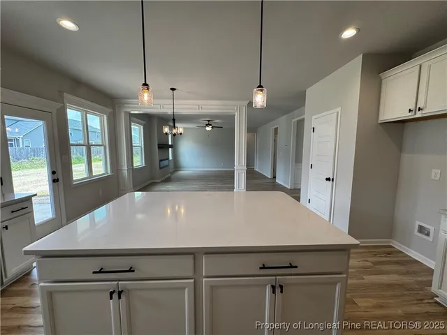 a kitchen with kitchen island a refrigerator stove and cabinets