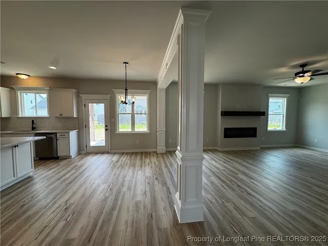a view of a kitchen and an empty room with wooden floor kitchen view