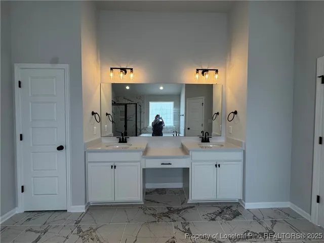 a spacious bathroom with a double vanity sink and a mirror