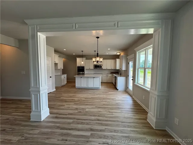 a large kitchen with stainless steel appliances kitchen island granite countertop a refrigerator and a view of living room