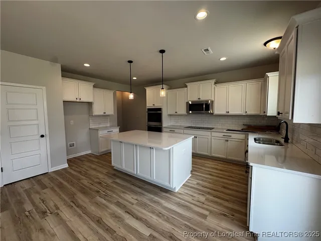 an open kitchen with white cabinets and stainless steel appliances