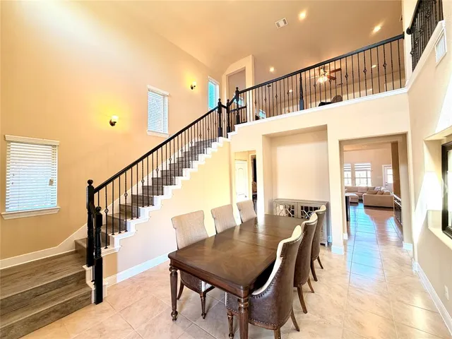 a dining room with wooden floor a chandelier a wooden table and chairs