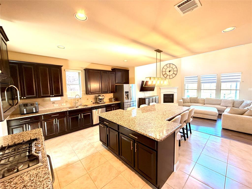 2403 Rosemary Lane Rowlett, TX 75089 - Photo 20 of 20 a kitchen with stainless steel appliances granite countertop a stove top oven a sink dishwasher and couches with wooden floor