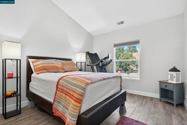 a bedroom with bed and wooden floor