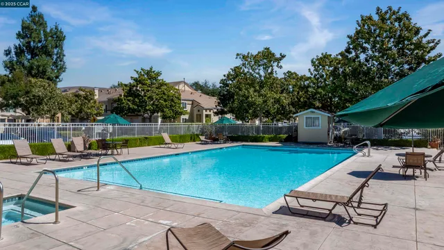 a view of a backyard with swimming pool and sitting area