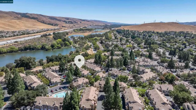 an aerial view of mountain with residential house and lake view