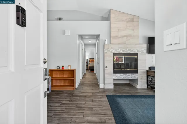 a hallway with wooden floor and fireplace