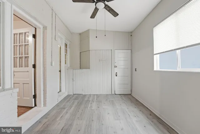 a view of a hallway with wooden floor and a chandelier fan