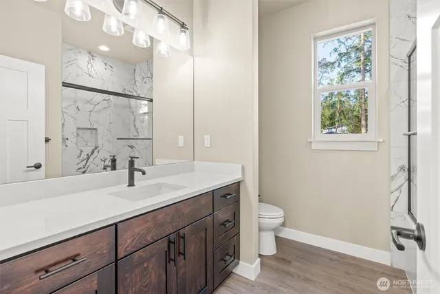 a bathroom with a sink a toilet and a large mirror