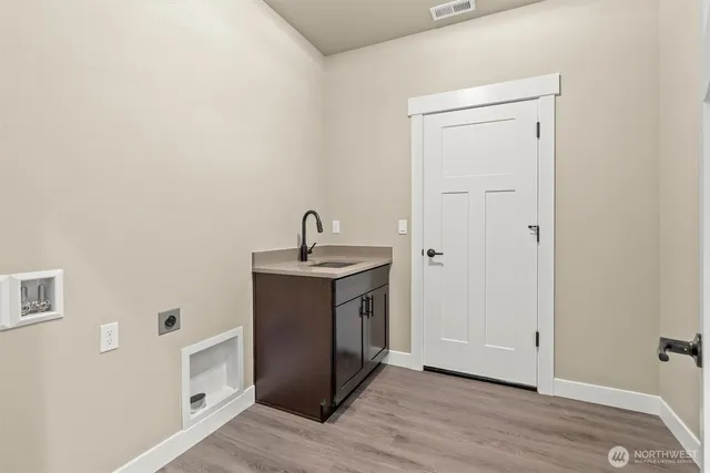 a view of a kitchen with white cabinets and wooden floor