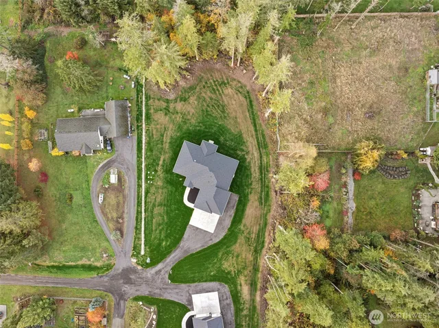 an aerial view of a house with a yard and lake view