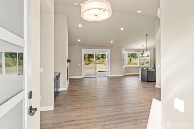 an empty room and a way to kitchen with wooden floor