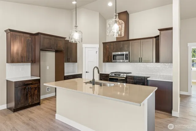 a kitchen with stainless steel appliances granite countertop a sink stove and refrigerator