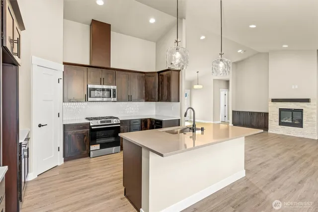 a large kitchen with stainless steel appliances a large center island attached withe living room