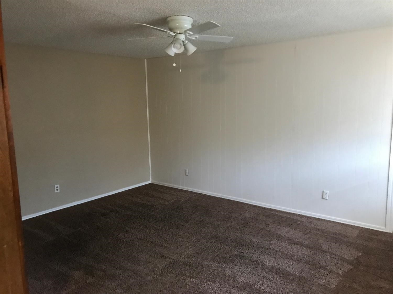 1608 59th Street, Unit 3 Lubbock, TX 79412 - Photo 7 of 8 an empty room with a fan & a ceiling fan