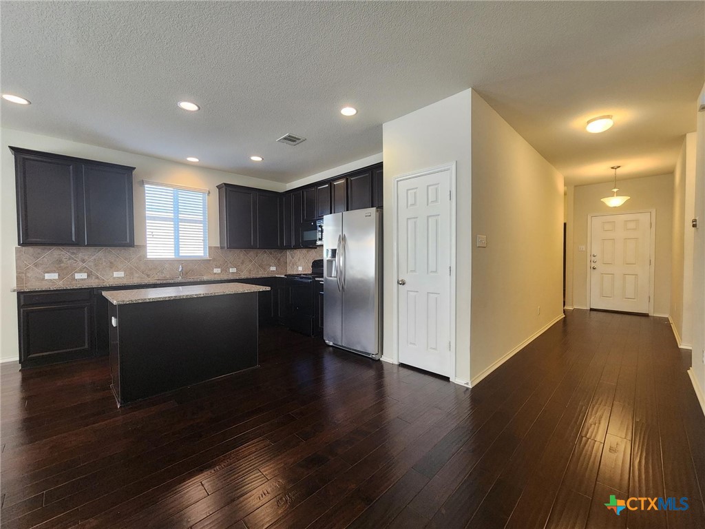 5822 Hopkins Drive Temple, TX 76502 - Photo 13 of 32 a kitchen with stainless steel appliances granite countertop a refrigerator a sink a stove and wooden floors