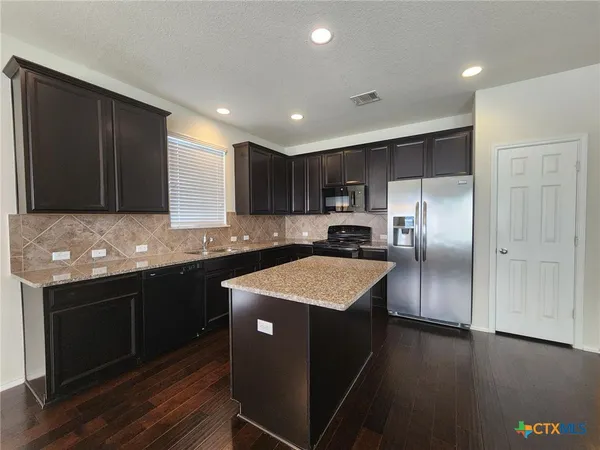 a kitchen with a refrigerator sink and stove