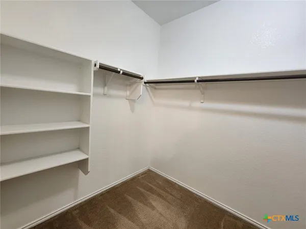 a view of walk in closet with empty racks