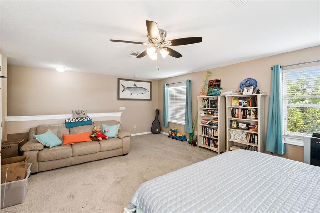 8484 Dover View Lane Orlando, FL 32829 - Photo 19 of 41 a bedroom with a bed and a bookshelf
