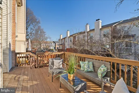a view of a balcony with wooden floor and outdoor seating