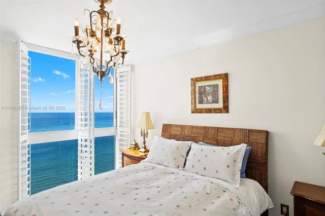 a bedroom with a large bed and a chandelier